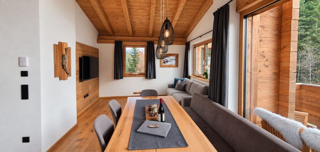 Heller Wohn- und Essbereich eines Zeitfrei Chalet Apartments mit warmen Holzelementen
