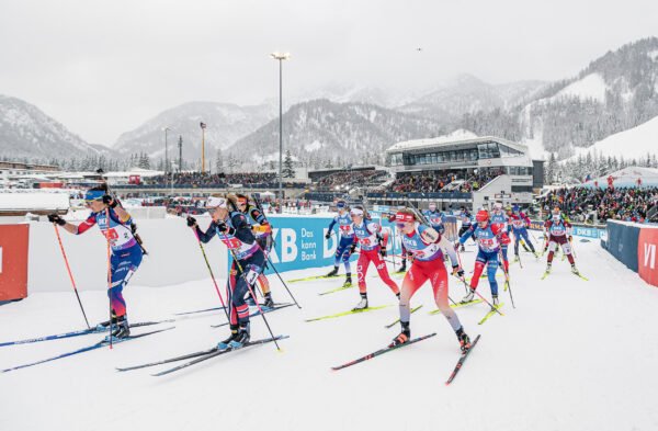 Start des Biathlon-Weltcups in Hochfilzen mit zahlreichen internationalen Athletinnen auf Skiern vor voll besetzten Tribünen und schneebedeckter Bergkulisse.