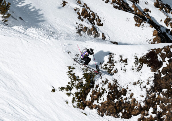 Ein Freeskier fährt steil und präzise durch felsiges Gelände