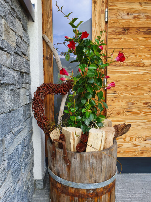 Sommerliche Blumendeko im Fass mit Rose