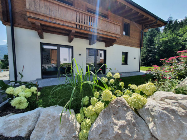 Sommerliche Chaletfassade mit Holzläden und Balkon