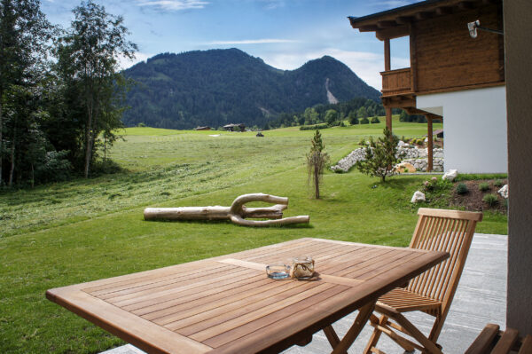 Großer Holztisch auf Terrasse mit Blick ins Tal
