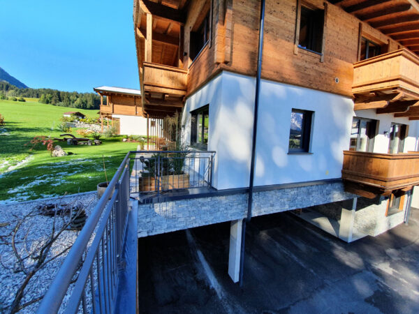 Südseite des Chalets mit Balkon und Bergwiese
