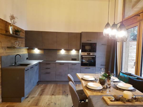 Moderne Naturholzküche mit Essbereich und Pendelleuchten im Chalet