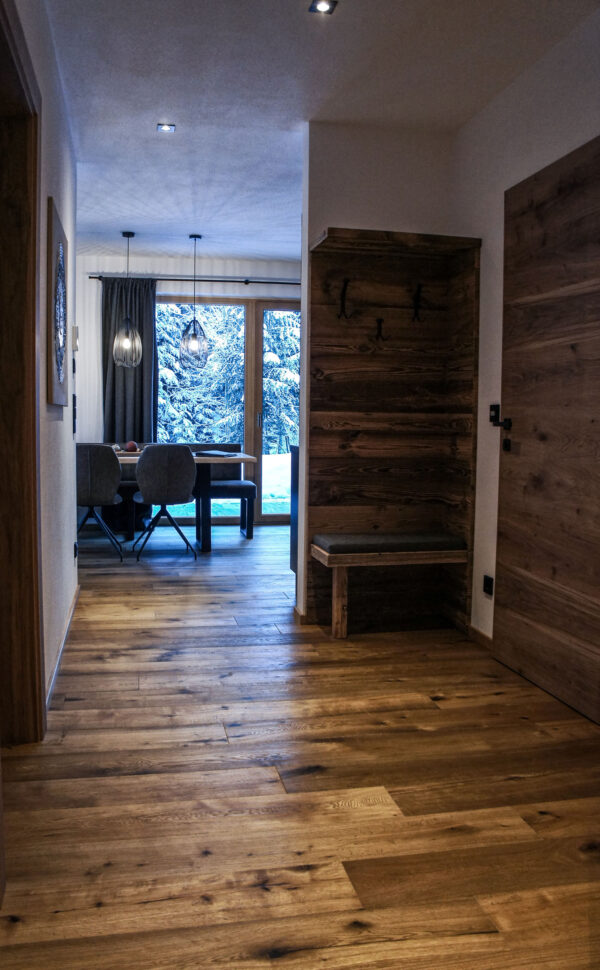 Heller Gang mit Holzboden und Altholzverkleidung