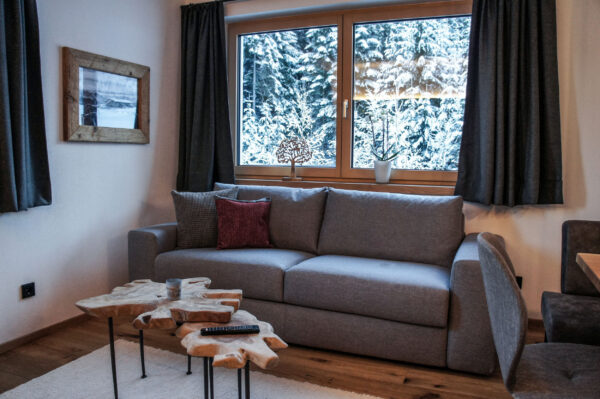 Gemütliches Sofa vor Panoramafenster mit Bergblick