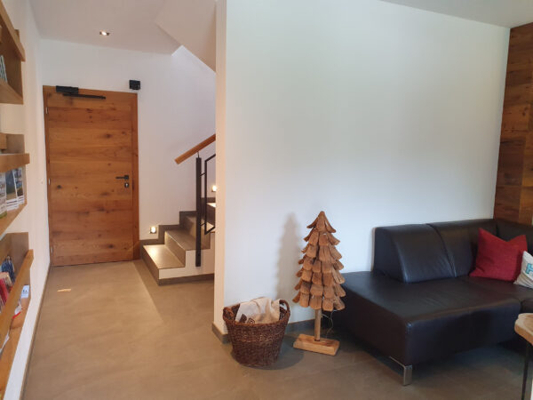 Gemütliche Lounge mit Dekoration und Treppe im Chalet zeitfrei in Fieberbrunn – stilvolles Ambiente für Ihre Auszeit in Tirol.