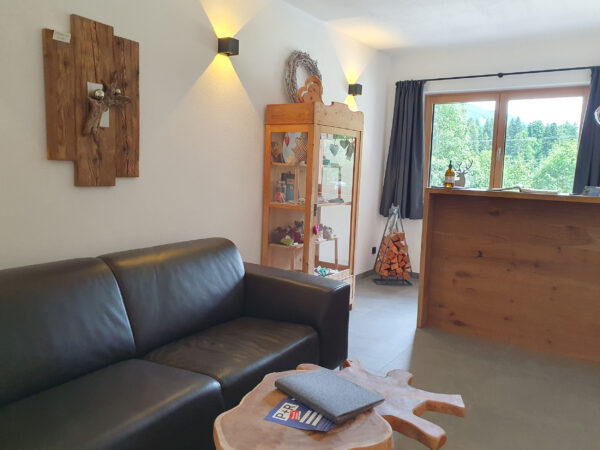 Heller Aufenthaltsraum mit gemütlichem Sofa und Panoramafenster im Chalet zeitfrei Fieberbrunn